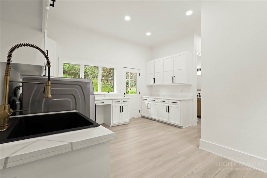 140 Wilson Ridge Road Boone, NC 28607 - Photo 25 of 48 a kitchen with stainless steel appliances kitchen island a white counter top and a wooden floors