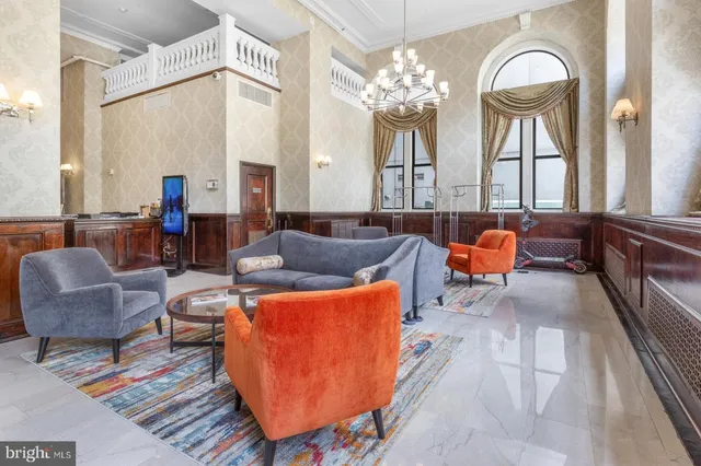 a living room with furniture a large window and a chandelier