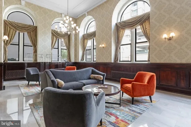 a living room with furniture a chandelier and a large mirror