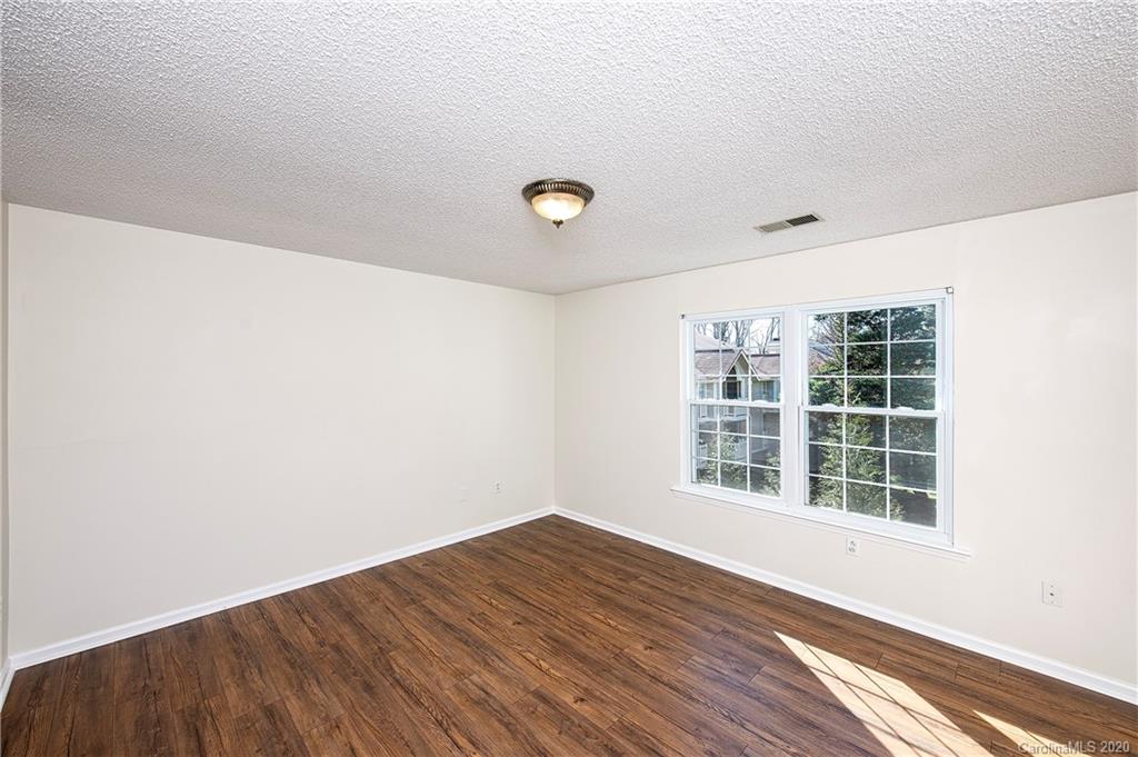 5003 Sharon Road, Unit R Charlotte, NC 28210 - Photo 11 of 23 a view of empty room with wooden floor and fan