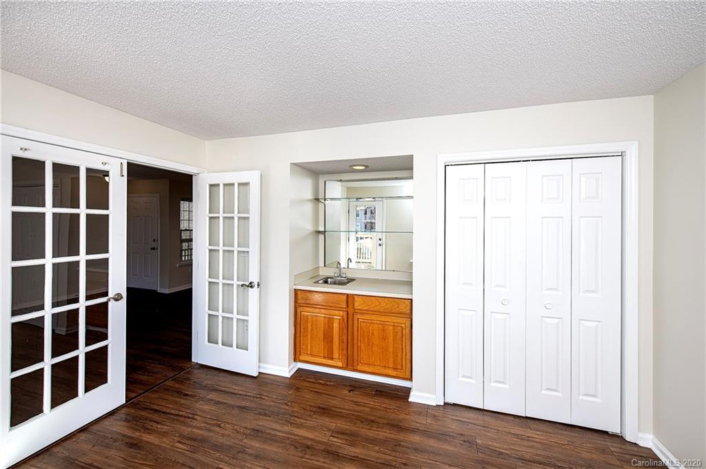 5003 Sharon Road, Unit R Charlotte, NC 28210 - Photo 12 of 23 an empty room with wooden floor and windows