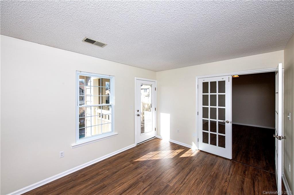 5003 Sharon Road, Unit R Charlotte, NC 28210 - Photo 13 of 23 an empty room with wooden floor and windows