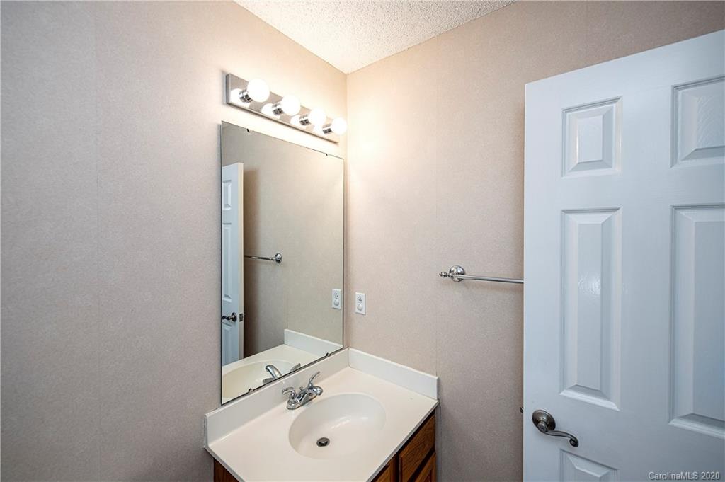 5003 Sharon Road, Unit R Charlotte, NC 28210 - Photo 14 of 23 a bathroom with a sink a mirror and vanity