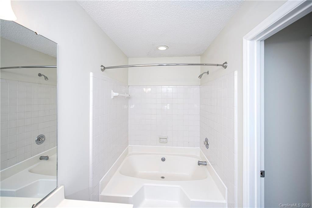 5003 Sharon Road, Unit R Charlotte, NC 28210 - Photo 18 of 23 a bathroom with a bathtub shower and toilet