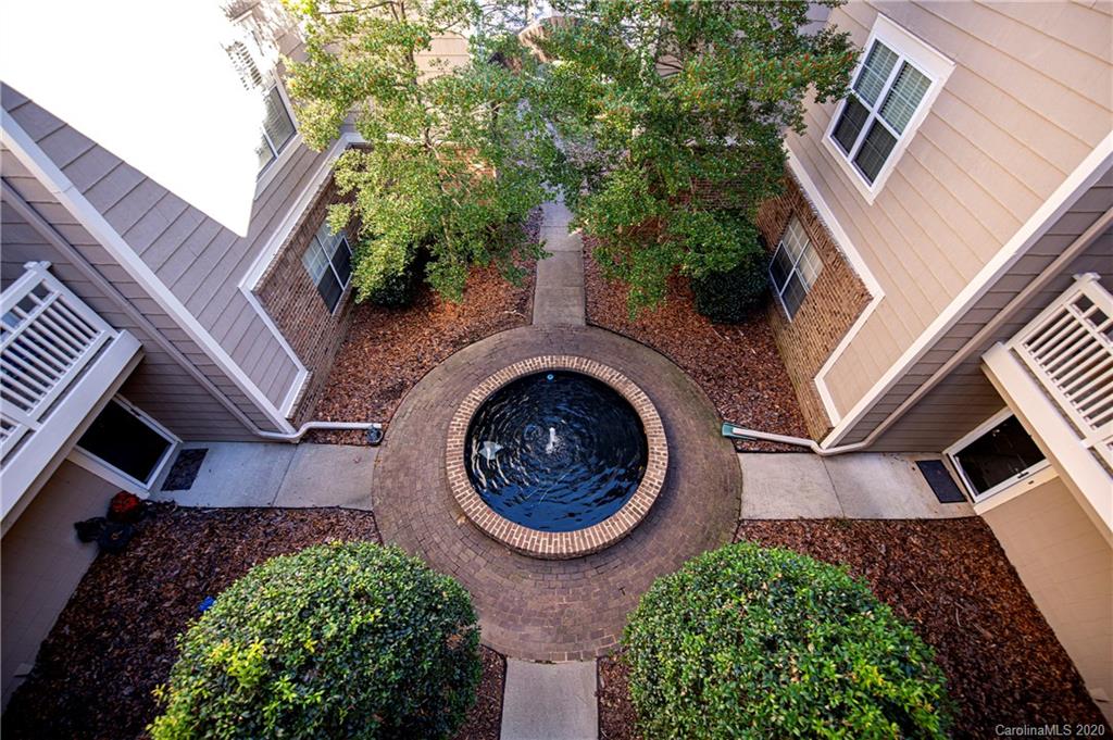 5003 Sharon Road, Unit R Charlotte, NC 28210 - Photo 22 of 23 a view of a house with a garden and trees