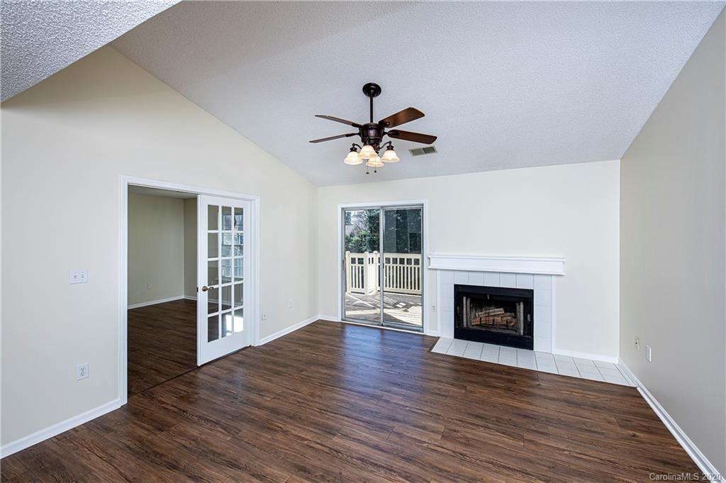 5003 Sharon Road, Unit R Charlotte, NC 28210 - Photo 4 of 23 an empty room with wooden floor a fireplace and a window