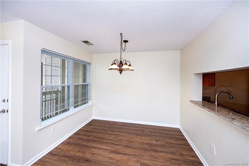 5003 Sharon Road, Unit R Charlotte, NC 28210 - Photo 5 of 23 a view of a room with wooden floor ceiling fan and windows