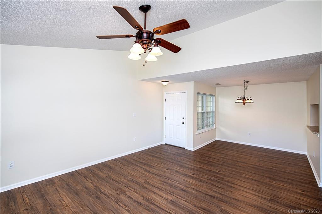 5003 Sharon Road, Unit R Charlotte, NC 28210 - Photo 6 of 23 an empty room with wooden floor a ceiling fan and closet