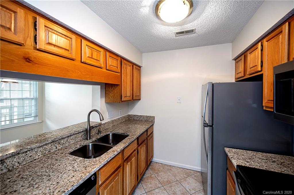 5003 Sharon Road, Unit R Charlotte, NC 28210 - Photo 8 of 23 a kitchen with stainless steel appliances granite countertop a sink stove and refrigerator