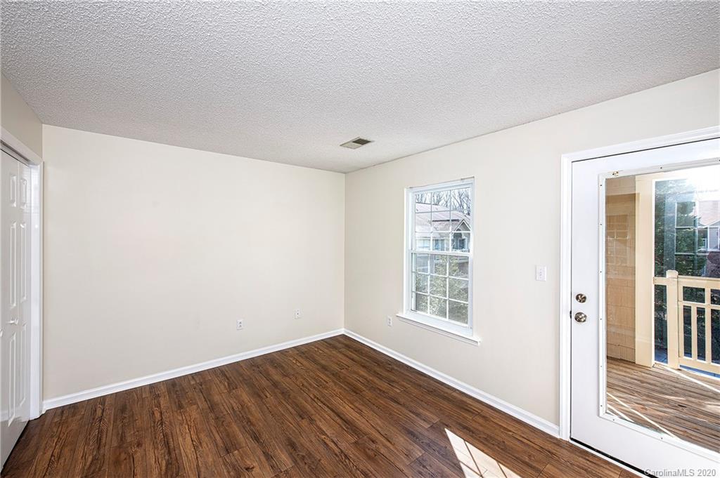 5003 Sharon Road, Unit R Charlotte, NC 28210 - Photo 10 of 23 a view of an empty room with wooden floor and a window