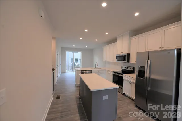 a kitchen with stainless steel appliances a refrigerator stove microwave and sink