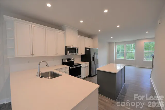 a kitchen with stainless steel appliances a sink stove and refrigerator
