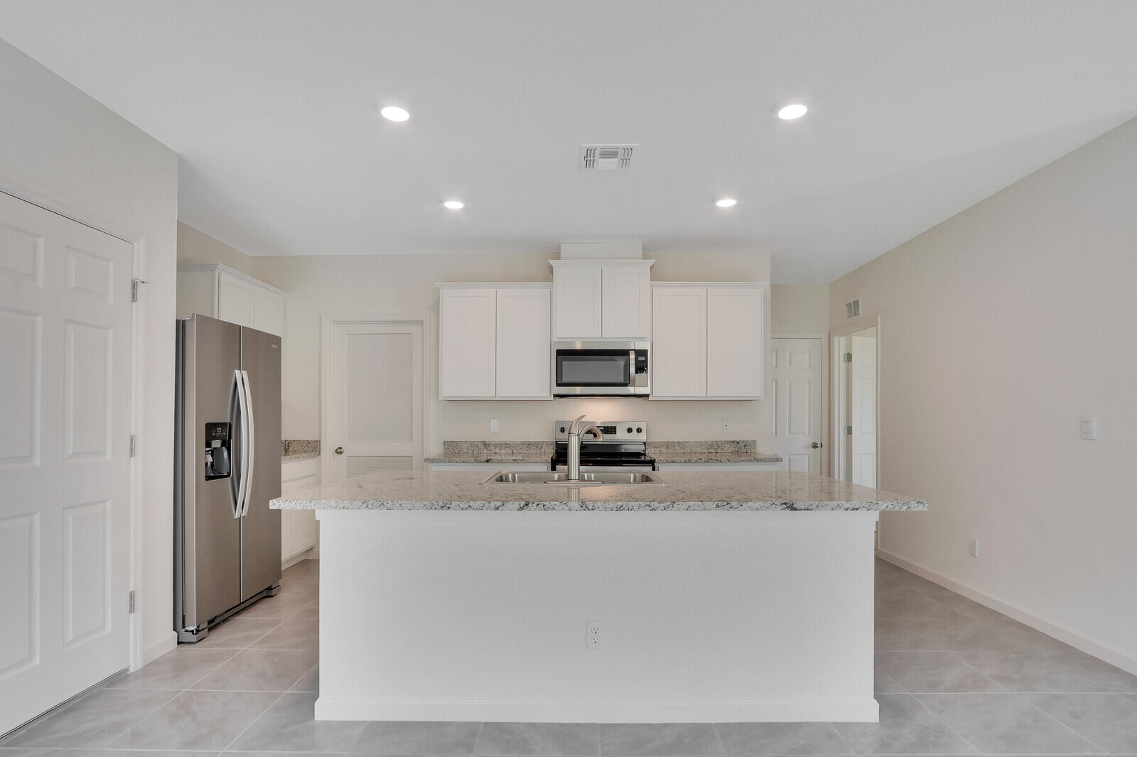 12335 Southwest Nettuno Way Port Port St. Lucie, FL 34987 - Photo 12 of 33 a kitchen with stainless steel appliances granite countertop a sink a stove a refrigerator and a refrigerator