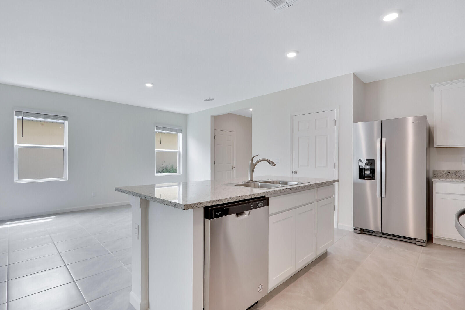 12335 Southwest Nettuno Way Port Port St. Lucie, FL 34987 - Photo 15 of 33 a kitchen with stainless steel appliances a sink and a refrigerator