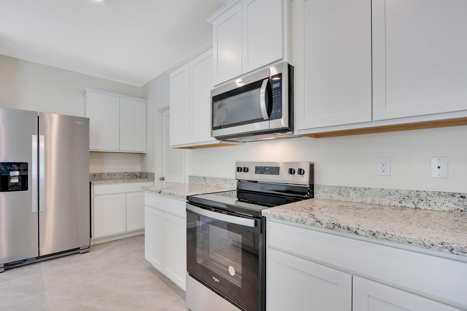12335 Southwest Nettuno Way Port Port St. Lucie, FL 34987 - Photo 16 of 33 a kitchen with granite countertop cabinets stainless steel appliances and a sink