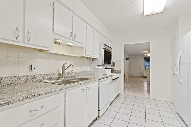a kitchen with granite countertop a sink and cabinets