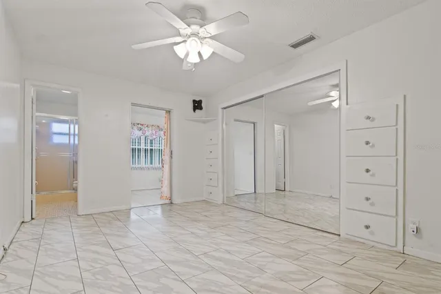 an empty room with closet and fan