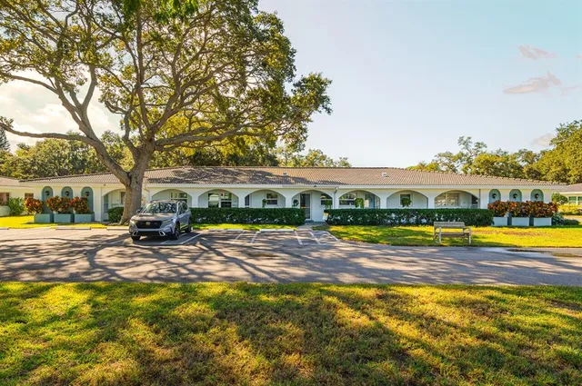 a view of swimming pool with lawn chairs and plants