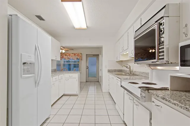 a kitchen with white cabinets and appliances