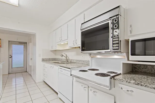 a kitchen with stainless steel appliances a stove microwave and sink