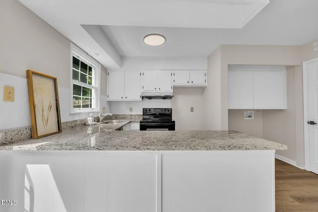 a kitchen with granite countertop a sink cabinets and window