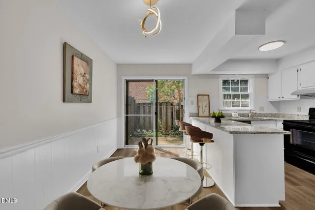 a kitchen with a table chairs and cabinets
