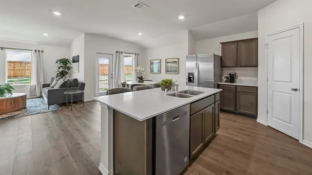 a kitchen with sink stove and refrigerator