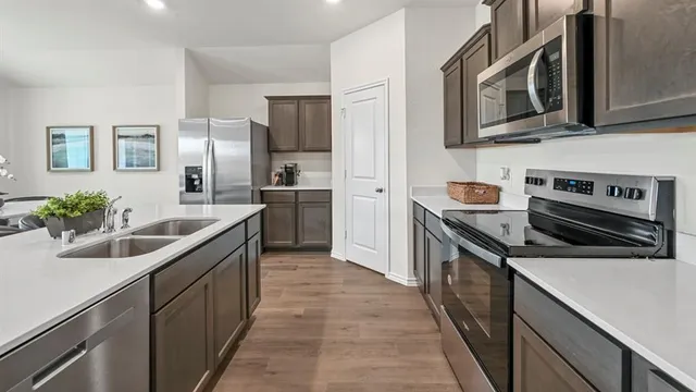 a kitchen with stainless steel appliances granite countertop a sink stove and refrigerator