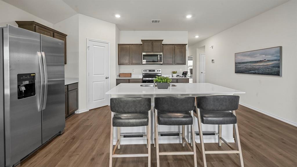 3264 Spaulding Drive Paris, TX 75460 - Photo 22 of 33 a kitchen with kitchen island a refrigerator and a stove
