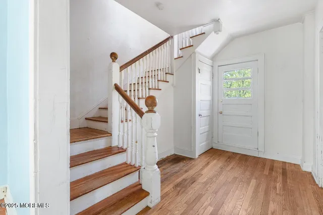 a view of entryway and hall with wooden floor