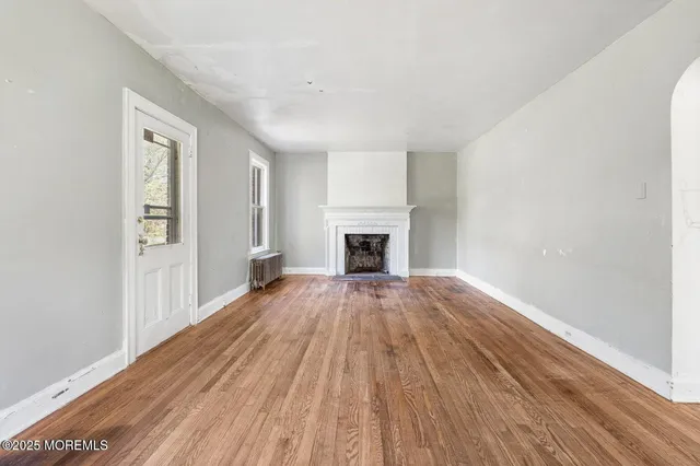 wooden floor fireplace and natural light in room