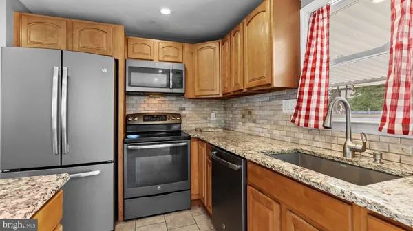 a kitchen with stainless steel appliances granite countertop a sink a stove and a refrigerator