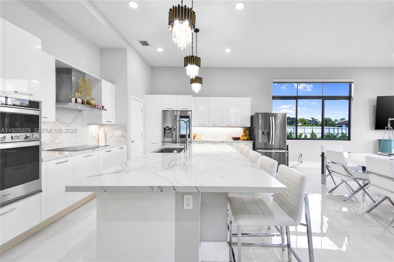 15846 Southwest 49th Street Southwest Ranches, FL 33331 - Photo 4 of 38 a large kitchen with kitchen island a large counter space a sink appliances and a counter top space