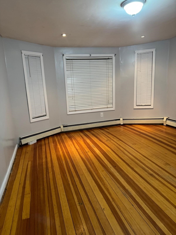16 Sargent Street, Unit 1 Lawrence, MA 01841 - Photo 4 of 8 a view of an empty room with wooden floor and a window