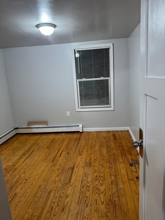 16 Sargent Street, Unit 1 Lawrence, MA 01841 - Photo 5 of 8 a view of an empty room with wooden floor and a window