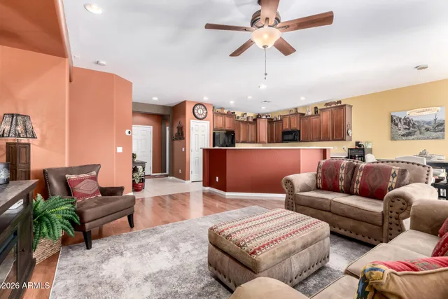 a living room with furniture kitchen view and a chandelier