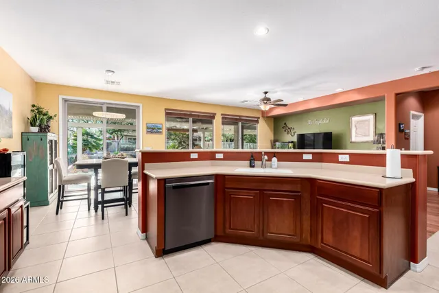a kitchen with a sink and chairs