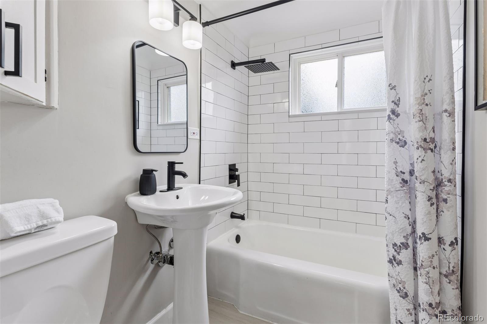 2255 Meade Street Denver, CO 80211 - Photo 16 of 30 a bathroom with a bathtub a sink a toilet and a mirror