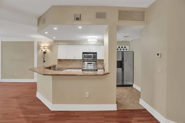 a view of kitchen with stainless steel appliances granite countertop refrigerator sink and stove