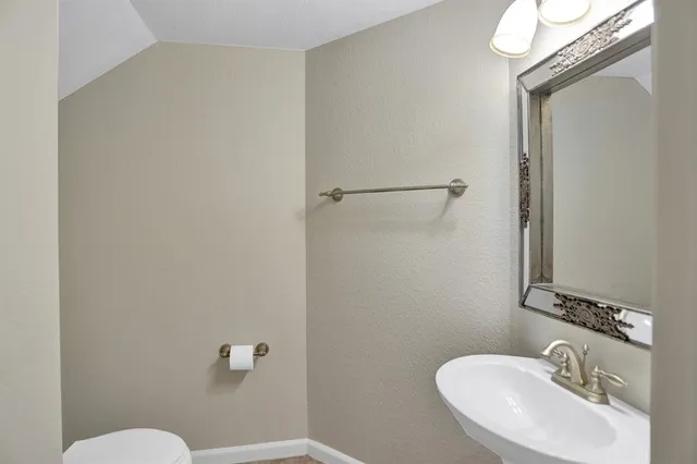 a bathroom with a sink mirror and toilet