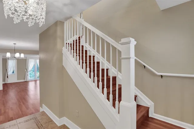 a view of staircase with lots of frames on wall and wooden floor