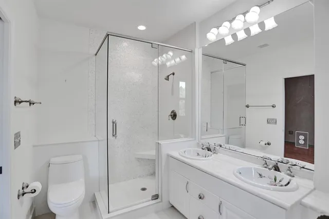 a bathroom with a sink double mirror and shower