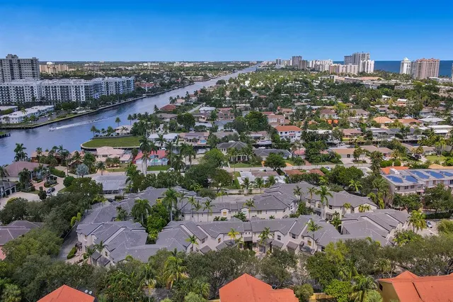 an aerial view of a city with lots of residential buildings ocean and mountain view in back
