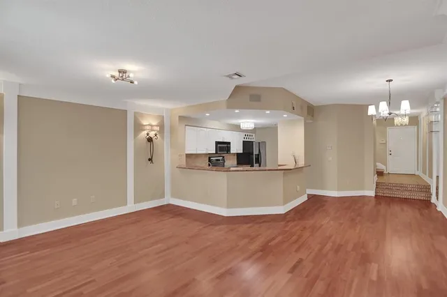 a view of a kitchen with wooden floor and a sink