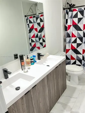 a bathroom with a sink a toilet and a shower curtain