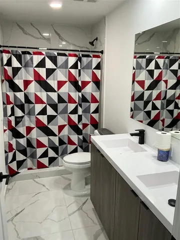a bathroom with a sink a toilet and shower curtain