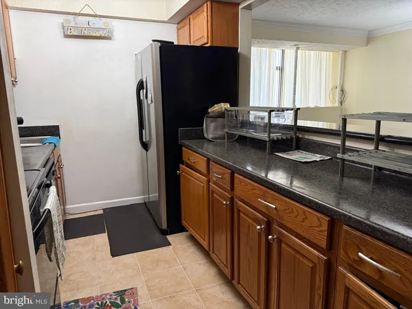 a kitchen with granite countertop a refrigerator and a sink