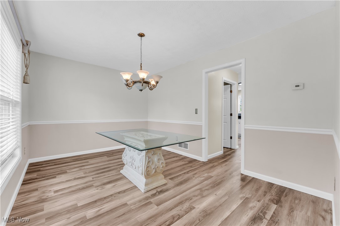 25861 Kennedy Ridge Road North Olmsted, OH 44070 - Photo 7 of 24 Unfurnished dining area with wood finished floors, a chandelier, and baseboards