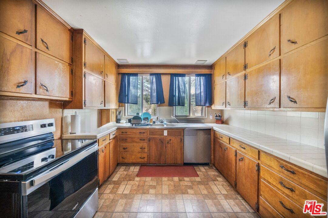 41322 De Luz Road Fallbrook, CA 92028 - Photo 5 of 29 a large kitchen with stainless steel appliances granite countertop a stove a sink dishwasher and cabinets