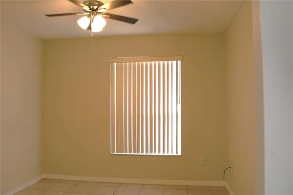 an empty room with a window and a fan